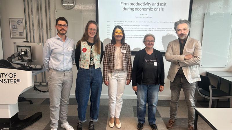 Group photo of all speakers at the workshop in front of a white board displaying the research project title.